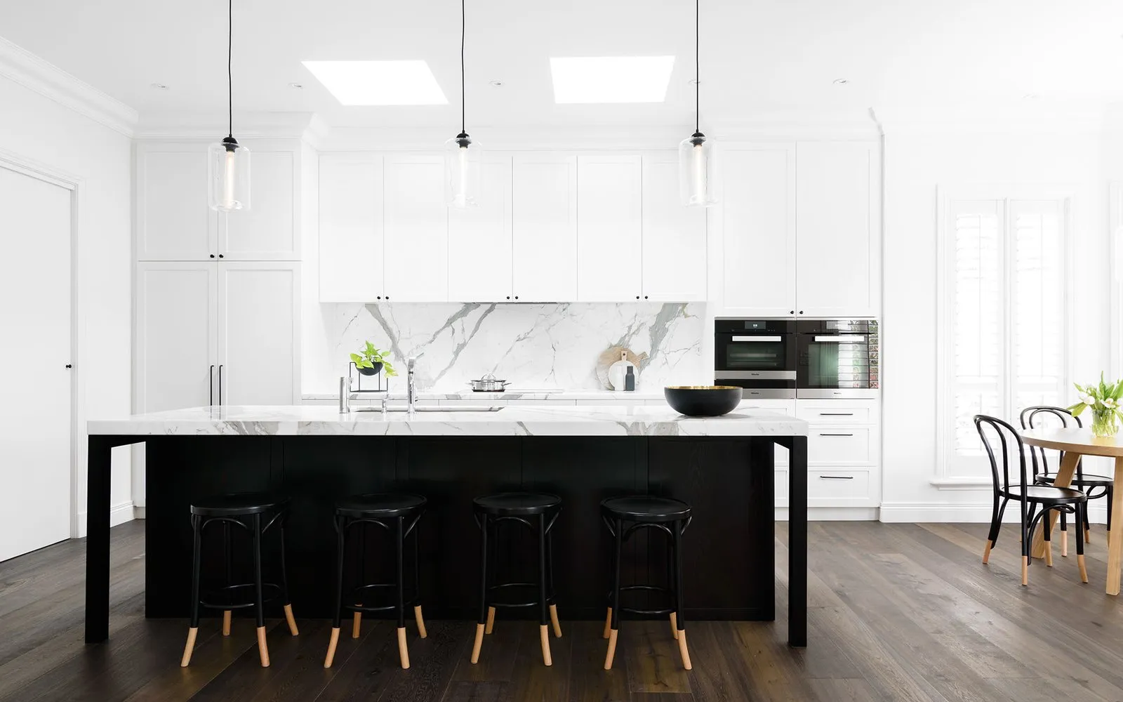 After: bright modern kitchen with white cabinetry and a deep charcoal island by Vamaylo