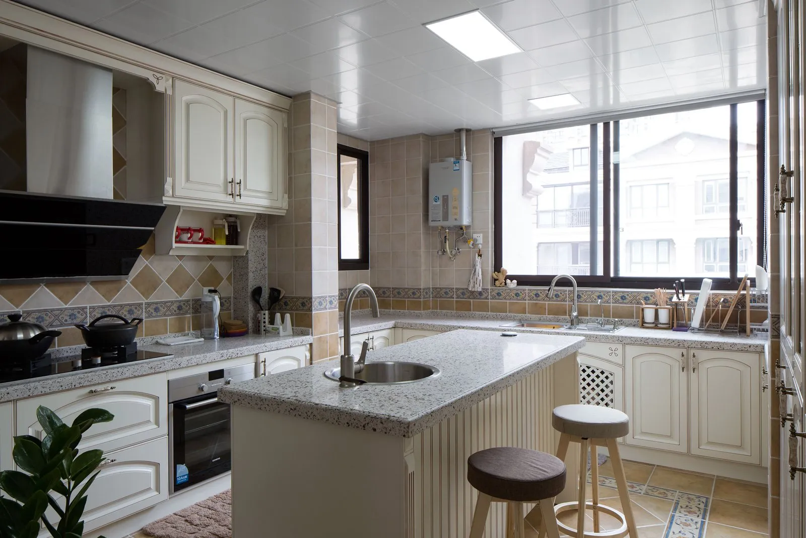 Farmhouse kitchen with an apron sink and warm white cabinetry by Vamaylo